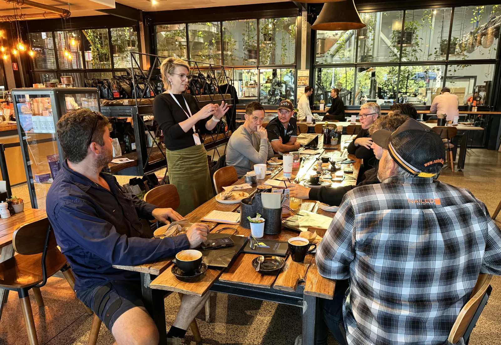 BuildUp members listening to a speaker during a Breakfast Boardroom at a café.